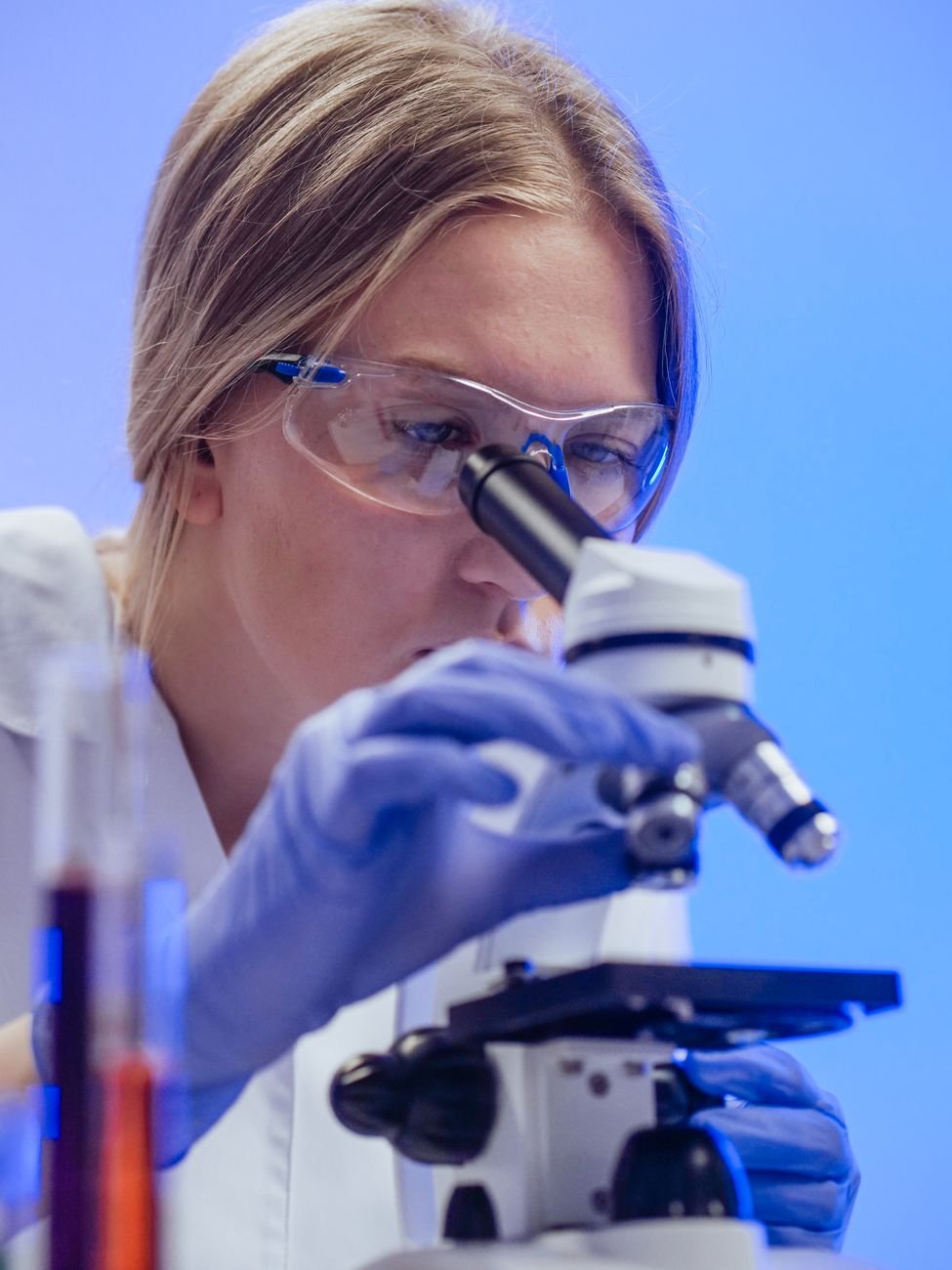 close up view of a woman examining a microscope slide